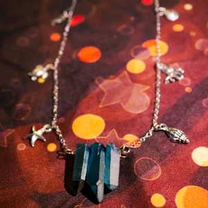 Halsband med havsblå kristaller och marina metallhängen - Handgjort (av mig) halsband med hängen av havsblå kristaller (blå apatit, tror jag) och metallhängen i form av bläckfisk, sköldpadda, snäckor m.m Halsbandet är gjort av en kedja som har en låsmekanism högst upp. 💙