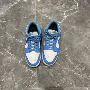 Nike Dunk Low University Blue - Bra skick, storlek 45, säljer mina dunka då jag ska köpa nya skor, nypris 5999. 