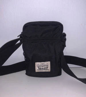 Väska Levis - En cool svart Levis axelremsväska med tre fack.  Inga repor eller fläckar, jätte fint skick.  Äkta Levis Kan skickas  Kan mötas upp  Kolla gärna in min profil där jag även säljer fler saker.