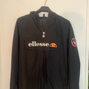 ellesse Anorak och vindjacka - Svart Ellesse anorak och vindjacka i storlek S.  Passform casual i mycket fint skick. Använd ett fåtal gånger.