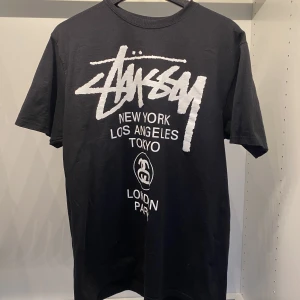 Stussy world tour tee - Stussy world tour tee storlek M svart. Använd 1-2gånger 10/10 skick inga cracks, dm för fler bilder  Köpare står för frakt (66kr)
