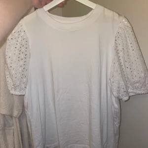 Topp - Vit topp med puffärmar av broderi strl L. Mycket fint skick. Köparen står för frakt, kan även mötas upp i Stockholm. Hör av er för fler bilder mm🥰