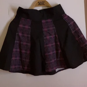 Kjol - Svart och lila rutig kjol insett tunnare material, inte så använd