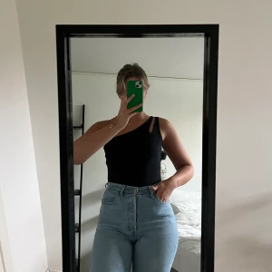 Svart body - En svart body med cool detalj över ena axeln. Bodyn är från bikbok i storlek M. I väldigt gott skick!