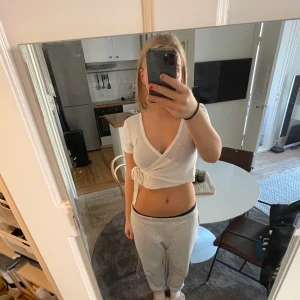 Vit stickad omlotttopp  - Vit stickad omlottopp med fina inbeordrade detaljer. Sparsamt använd 