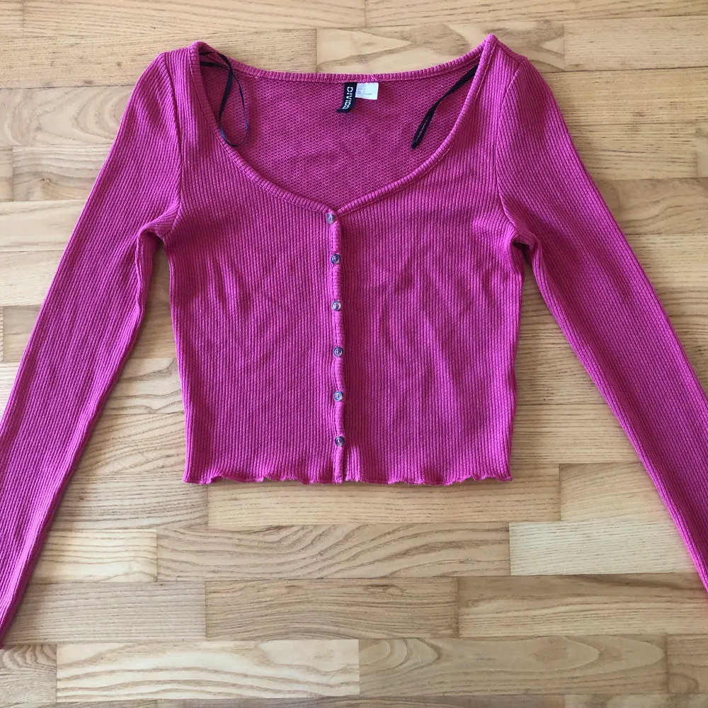 Urringad chockrosa tröja, polyester m.f syntetmaterial, en tillhörande knapp.. Tröjor & Koftor.