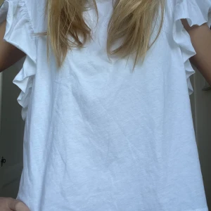 T-shirt - Denna super gulliga och fina volang t-shirten från zara. Perfekt att ha istället för att slänga på sig en vanlig tråkig t-shirt. Super söta volanger på ärmarna. Prislapp kvar. Tveka inte att skriva för flera bilder eller något du undrar över ❤️