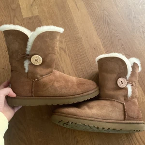 Bruna uggs med knapp - Säljer ett par bruna uggs med knapp, köpt för några år sedan men väldigt sparsamt använda. 