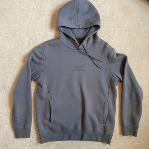 H&M grå hoodie, storlek S - Vanlig grå hoodie från H&M. Tyvärr för kort i ärmarna för mig vilket gjort att den använts max 3 gånger. Liten fläck vid högra ärmens början, men inget man tänker på.