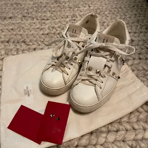 Valentino sneakers - Valentino garavani rockstud sneakers med guldiga nitar. Strl 37,5. Är skavda vid ena hälen men annars väldigt fint skick. Tvättas innan såklart! Kommer med äkthetsbevis och nitar och dustbag. Pris diskuterbart vid snabb affär. Köpare står för frakt! Kan tas med till Göteborg. 