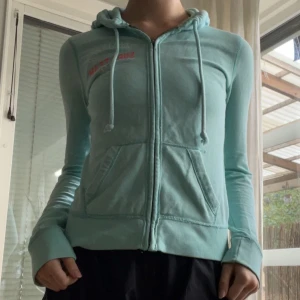 Munkis från Hollister - Hoodieee från Hollister, original å vintage. Lite sliten då den använts en del, därför säljs den billig. Dock fortfarande bra skick. Snygg färgklick🐬 xs 
