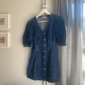 Jeansklänning ZARA - Fin jeansklänning från Zara! Storlek M. Inget att anmärka på förutom att det är någon typ av plast på guldknapparna som börjat gå upp på vissa. Se bild. Går att pilla av plasten. 100% bomull. 