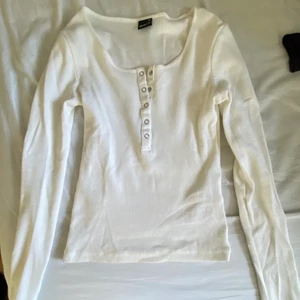 Vit långarmad med knappar - Från Gina, fint skick, passar både xs och s men skulle säkert också passa M 