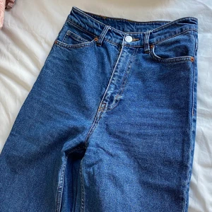 Mörkblå jeans från Monki - Mörkblåa jeans från Monki i superfint skick! Korta i modellen så passar dig som är 160 cm eller kortare, annars är dom ankellånga! Waist 25