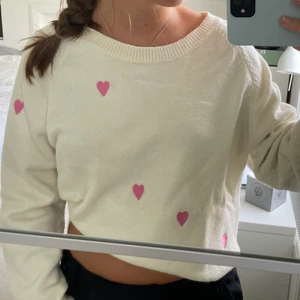 Vit stickad tröja med hjärtan - Supermysig stickad vit tröja med söta hjärtan. Går att ha uppvikt som på första bilden, eller som den är. Står ingen storlek men skulle uppskatta till S/M. Inköpt på liten butik i USA förra året. Osäker på material, men skulle gissa på kashmirblandning💕