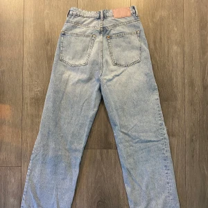 Blå jeans - Supersnygga raka blå jeans med hål på knänen, superfint skick och perfekta till hösten!