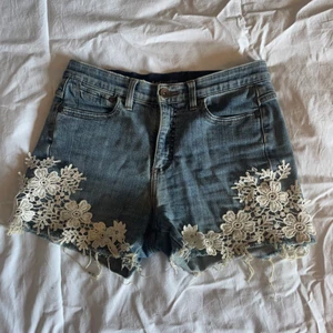 Jeansshorts med spetsdetalj - Jättesköna jeansshorts med spetsdetalj. Det står ”Lee” i dem samt på en lapp bak, men de är köpta utomlands så jag tror inte de är äkta - därav priset. Väldigt bekväma!🥰