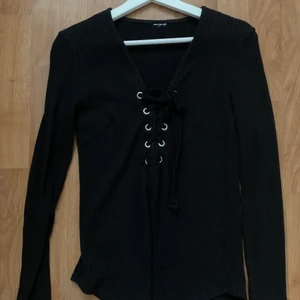 Ribbas tröja med snörning - En svart tröja som har snörning i mitten man kan anpassa efter den urringning man föredrar. Står ej storlek men passar XS/S och möjligt M.