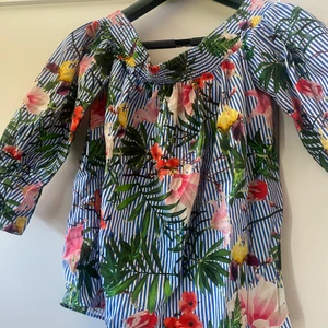 Blommig blus  - Blommig blus med rosett baktill. Använd fåtal gånger därav fint skick. Användbar nu till sommaren 🦋🥰