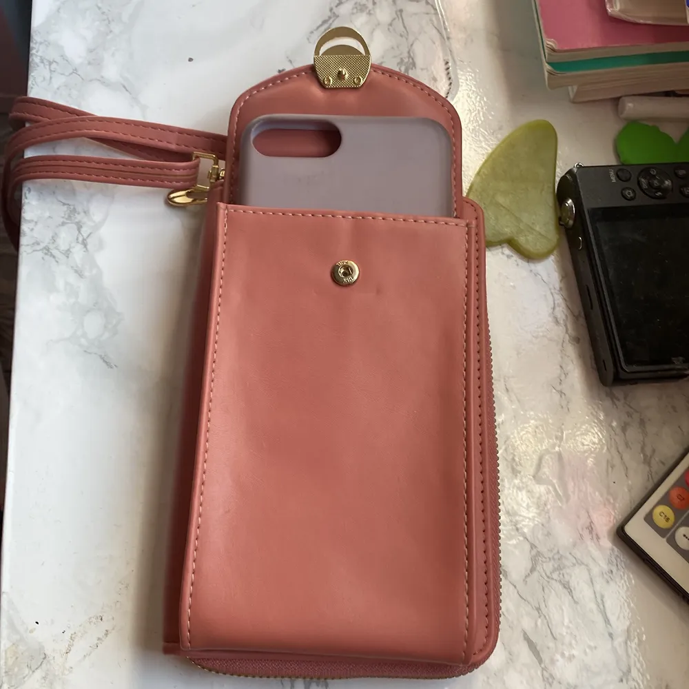 En rosa väska, finns ett eget plats till mobil, man kan lägga pengar,smink och mer. Köpt den från en känd affär i Egypten! Kostar 90kr köpt den för 200kr. Väskor.