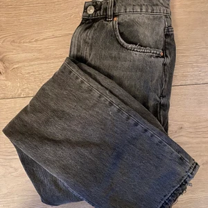 Raka grå/svarta jeans  - Raka jeans i urtvättad svart med slitna fötter, storlek 38 men passar både mindre och större beroende på önskad fit.