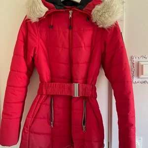Röd vinterjacka  - Röd vinter jacka  Nypris 1000kr Säljs för 500kr Fake päls  Storlek 36 men funkar även på en 38. 