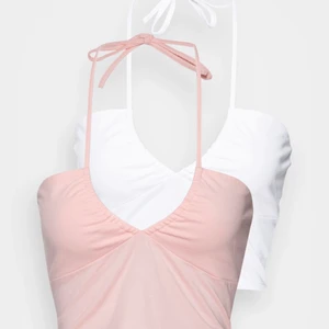 Två halternecktoppar - Två somriga halternecktoppar från Monki i vit och rosa. Aldrig använda. Strl S, passar XS-S