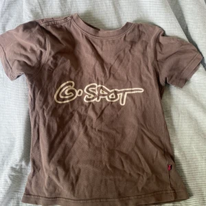 Tröja med tryck (köp inte via direkt, kontakta mig först) - Brun/beige t-shirt med trycket gspot. En skit ball baby tee men som tyvärr är för liten för mig så därför söker tröjan ett nytt hem. Passar perfekt till jeans eller linnebyxor. Passar både xs&s.  Bara att höra av sig till mig om man vill ha fler bilder.