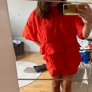 Röd klänning med volanger - Oversized röd/orange klänning från Zara med volanger. Skrynklig på bild