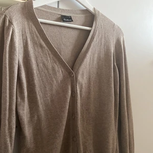 Beige/Brun kofta - En kofta med färgen beige/brun från Cubus. Säljer den för att den är för stor för mig och använd 1 gång endast. Den är också i bra skick!!