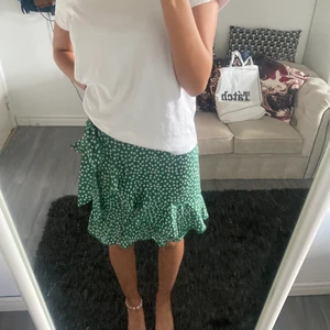 Grön blommig kjol - Denna kjolen är ifrån Shein, använd max 7 gånger, bra kvalitet. Den är i st 34 men passar även som 32 eftersom att man kan spänna åt den om man vill!