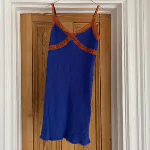 Jättefin klänning från Urban outfitters, mörkblå med spetsdetaljer i orange/brons/brunt, strechig och ganska kort. Inköpt förra året men sparsamt använd. 