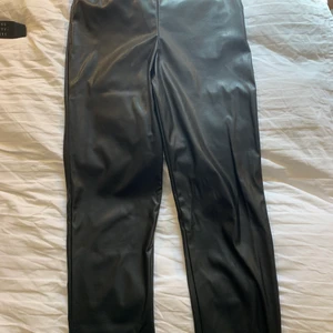 Byxor läder/skinn imitation, storlek 40 TALL - Ett par as snygga byxor i skinn/läderimitation ifrån ASOS TALL, byxorna är långa i benen (bra längd för mig som är 180 cm lång) men måste tyvärr sälja då min kropp har förändrats så dessa nu är förstora för mig!  (Frakt inte inkluderat i priset)