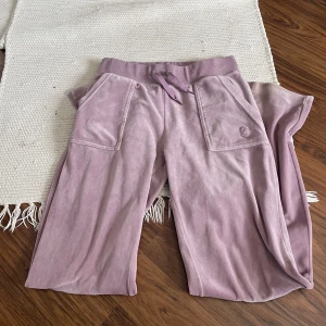 !!Juicy byxor till salu!! - Säljer ett par rosa/lila juicy byxor!! Äkta och köpte från juicy coutures hemsida, båda metall grejerna på snöret har trillat av. skriv för mer  info. 