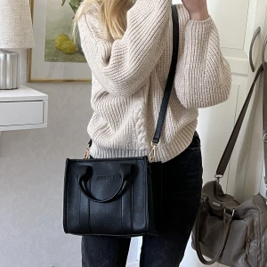 Svart axelremsväska  - Svart axelremsväska i konstläder, med dragkedja. Aldrig använd, så det finns inga slitage. Första bilden är ”framsidan” medan sista bilden är baksidan av väskan, så den är fin åt båda hållen!💖 För fler bilder samt bilder på insidan osv, skicka meddelande🥰