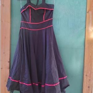 Rockabilly/50tal - Heart & roses från England. Kraftigt rejält tyg. Underkjol. Aldrig använd. Halterneck  Rollas innan försäljning eftersom den drar åt sig hår.