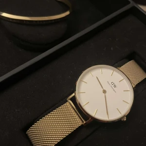 Daniel Wellington klocka & armband - Säljer min fina oanvända klocka med tillhörande armband som fortfarande är paketerad med kvitto och 2 års garanti. Petite Evergold har en äggskalsvit urtavla ett meshband med ljus guldplätering. Köpt från Stjärn Urmakarna för 1 månad sen.