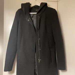 Kort kappa med luva - En svart kort kapp med luva. Lite tjockare material så en lite rejälare kappa som funkar i vår/vinter och höst. Sparsamt använd. (Hund finns i hemmet)
