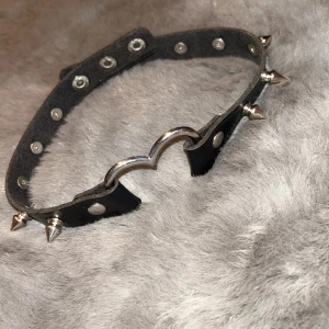 ”Chocker” med nitar  - Saljer min chocker med nitar och ett hjärta, den har mest legat i min garderob. Bra skick inget slitage!😊