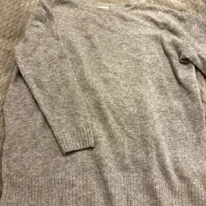 En grå stickad tröja från h&m. Den har slits på båda sidorna. Storlek m men skulle säga att d är mer åt S 