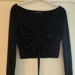 Cropped top - Långärmad cropped tröja där man kan välja själv hur framsidan ska se ut! Bra skick. Fungerar i flera storlekar tack vare att man själv kan justera längden som man vill ha den.