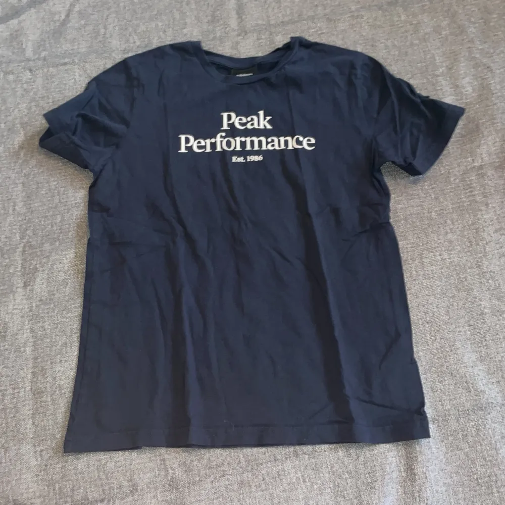 En helt ny peak t-shirt i färg marinblå i storlek 160. T-shirts.