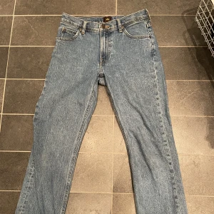 Mörkblå ueans - Mörkblå jeans från Lee. Bild nt 1 och 2 är tagna i konstigt ljus, och bild nr 3 visar den korrekta färgen på byxorna. Jeansen har några missfärgningar vid midjan och längst ned.  