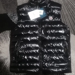 Moncler väst - Hej på dig som läser, har tänkt att sälja min brors väst efter som att han inte passar i den,(KOM MED ETT BUD PÅ DM) den är typ knappt använd och är i bra skick, plus att den är skön och sitter bra på kroppen. (Akopia) (köparen står för frakten) 