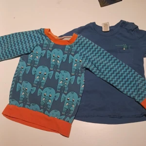 Tröjor barn - 1st blå med elefantmotiv, 1st mörkblå med en krokodil i fickan. Storlek 86. Använt skick.
