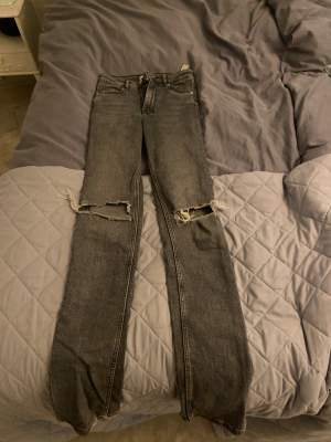Ett par ljusgråa jeans från Zara. Lite bootcut aktiga med slits längst ner. Dom är andvända några få gånger och i jätte bra skick. Sitter nån cm under naveln