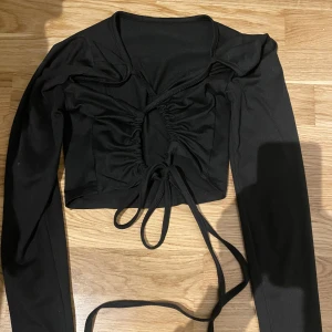 Tröja med knytning i ryggem - Festlig samt vardaglig långärmad tröja med öppen rygg och knytningar. Väldigt bekvämt material samt sitter snyggt. Köpt på Nelly.com 