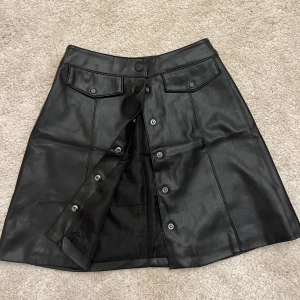 Kjol - Svart skinnkjol  Storlek xs Med knappar