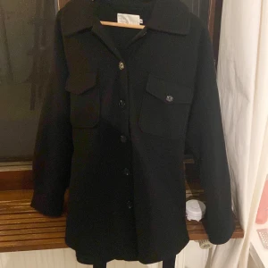 Kappa - Svart kappar från Nelly, nästan nyskick  Kan knäppas med knappar och ett band  Köpt för 450 och säljs inte mer 