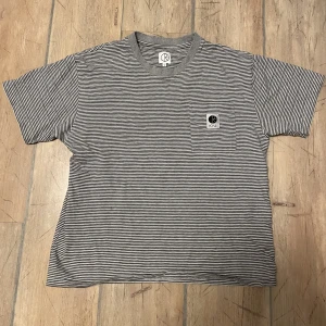 Polar tshirt stl S - Grå/svart/vit-randig polar tisha som har legat för länge i min garderob då den är lite för liten för mig. Skön och snygg boxy passform, ganska kort i längden. Använd 10 ggr ish. Nypris: 600kr